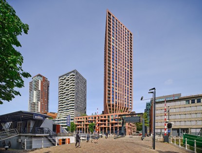 Modern buildings in an urban setting, with a prominent tall orange tower in the foreground.