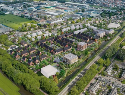 Aerial view of a green residential area with various houses and gardens, surrounded by trees and a waterway.