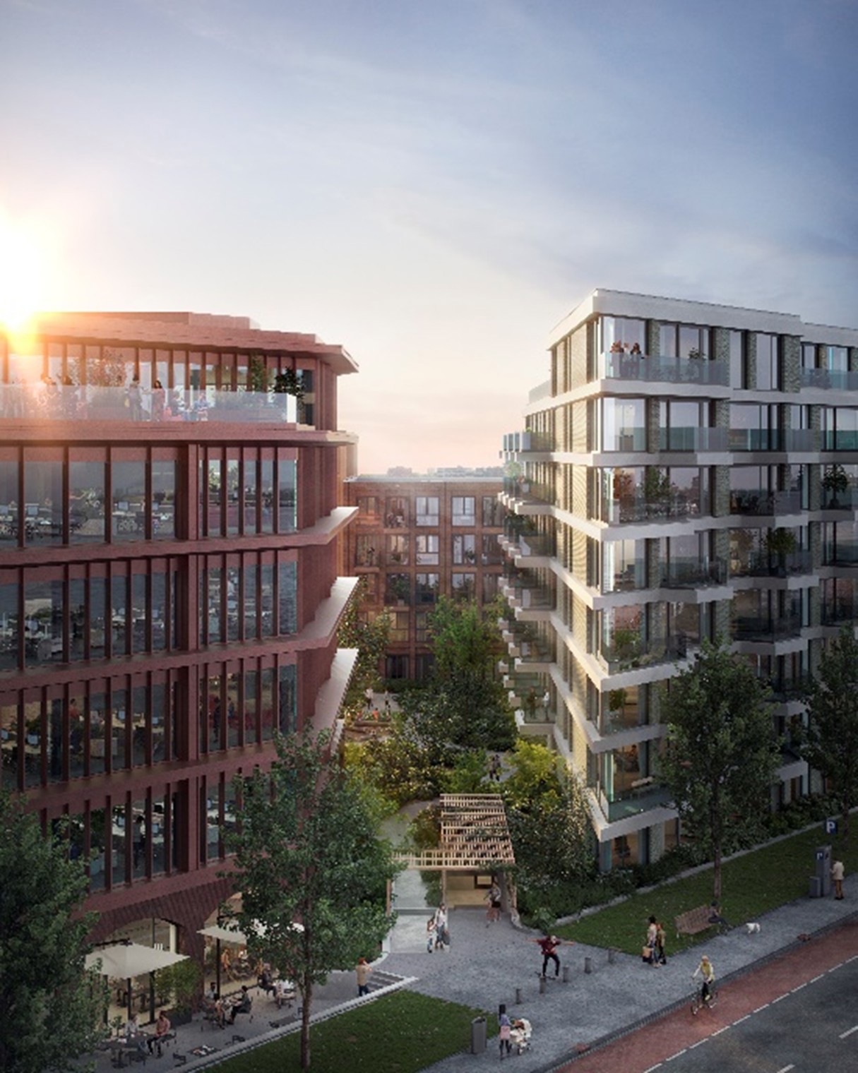 Moderne appartementencomplexen met zonnepanelen en groene gebieden, gefotografeerd tijdens de zonsondergang.