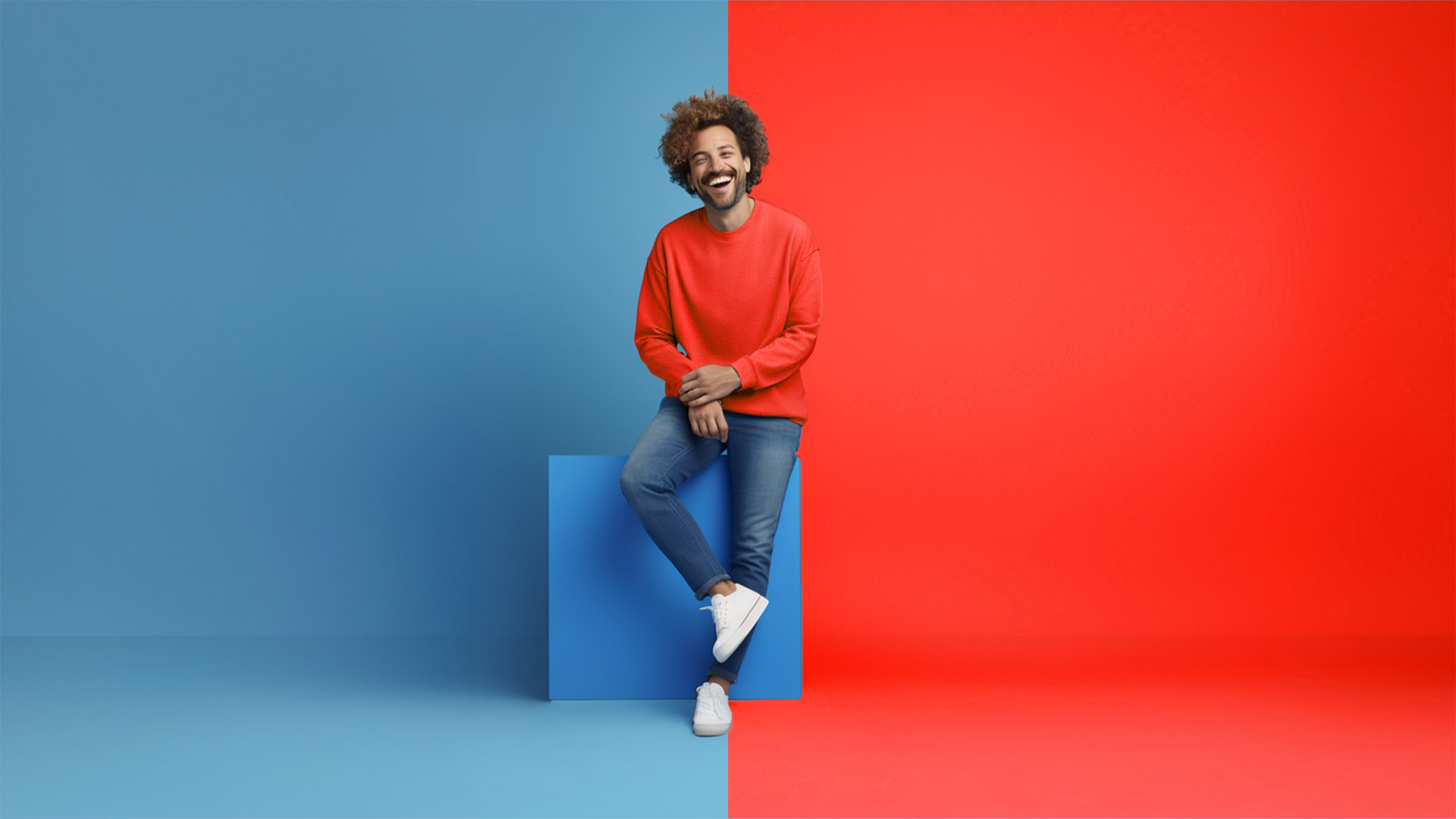 Persoon in rode trui en spijkerbroek staat op een blauw blok, omringd door een blauwe en een rode achtergrond.