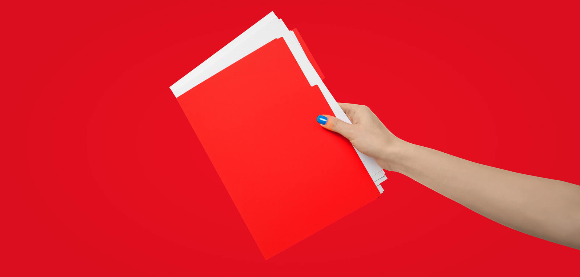 Hand die een stapel rode mappen vasthoudt tegen een heldere rode achtergrond.