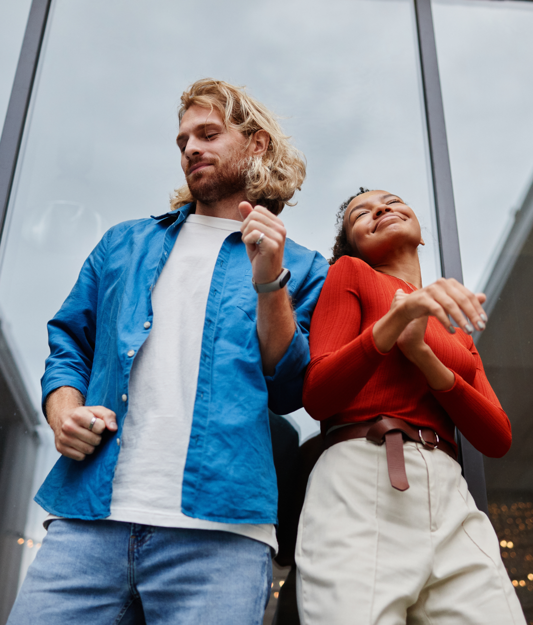 Twee mensen genieten van een buitenactiviteit, met de nadruk op hun enthousiaste houding en gebaren, terwijl ze trendy kleding dragen.