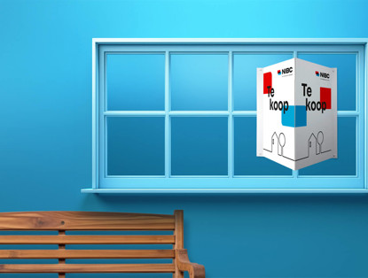 Witte Te koop-doos met de tekst Te koop in een raam, op een blauwe achtergrond, naast een houten bank.