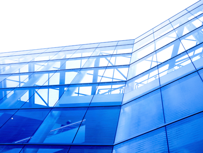 Blue glass facade of a modern office building with visible steel structure.