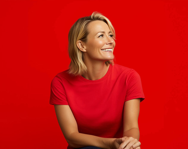 Vrouw in een felrood shirt met een neutrale uitstraling voor een rode achtergrond.