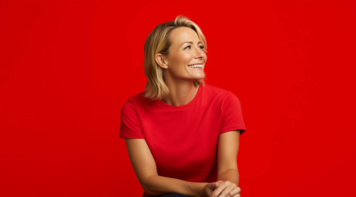 Vrouw in een felrood shirt met een neutrale uitstraling voor een rode achtergrond.