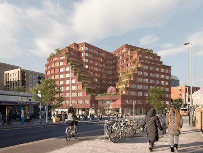 Modern apartment buildings with red facades, surrounded by green plants, with cyclists and pedestrians on the street.