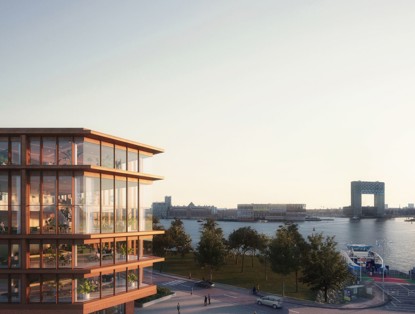 Modern office building with a glass facade and wooden accents, situated by a waterfront with parks and trees in the foreground.