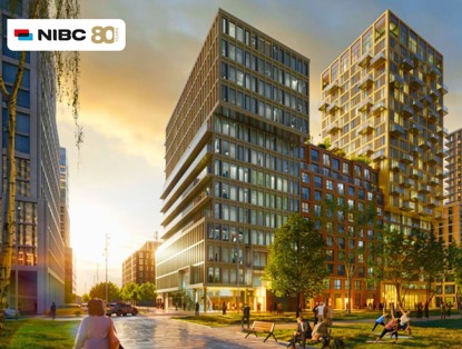 Modern apartment buildings surrounded by greenery, illuminated by the setting sun.
